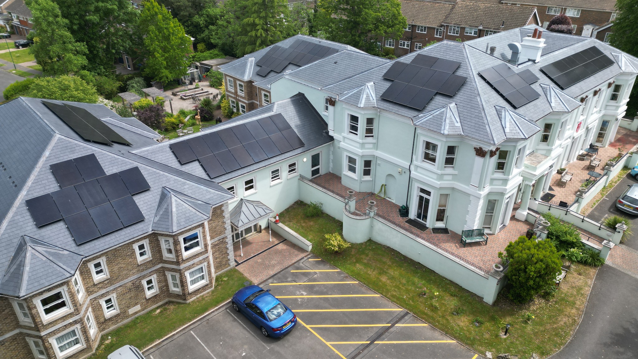 Aerial view of solar PV arrays across several slate roof sections.